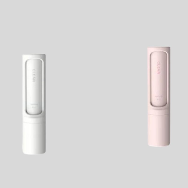 Two slim rectangular personal care devices shown on a light gray background, one in white and one in pale pink. Each device has a rounded rectangular top section with a vertical brand mark reading CLEAN.