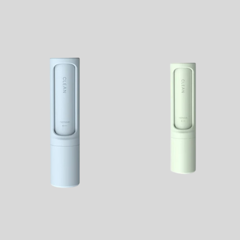 Two slim cylindrical cosmetic tubes on a light gray background, one in pale icy blue and one in pale mint green. Each tube has a vertical rectangular window showing the brand name CLEAN.