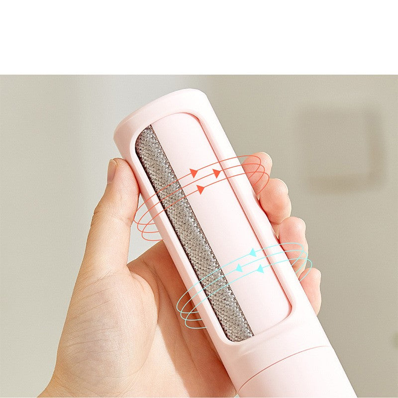 Pink pet hair remover held in a hand with a neutral background