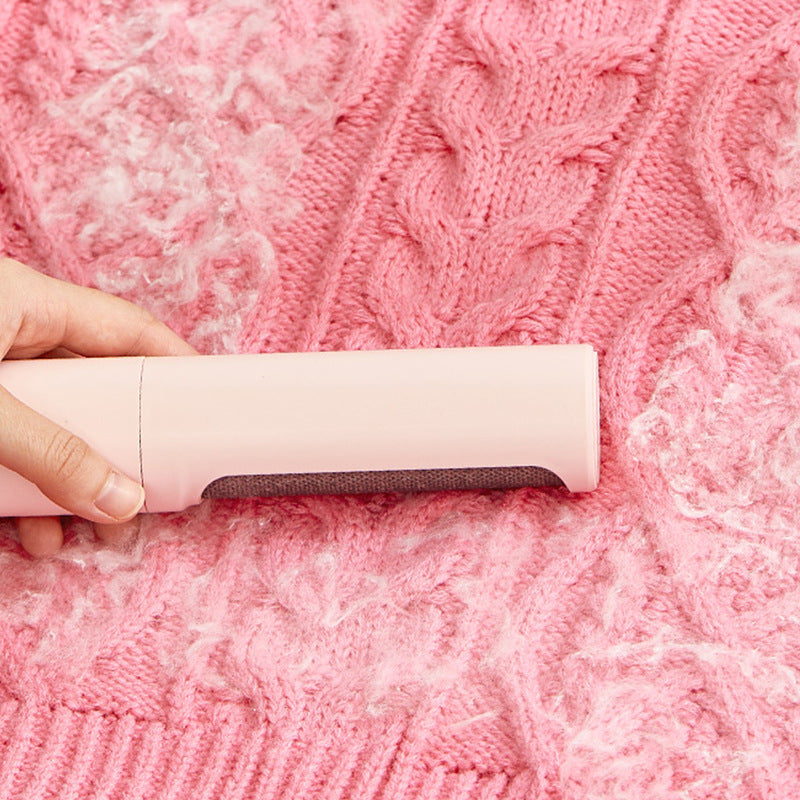 Person using a pink lint roller on a pink textured fabric