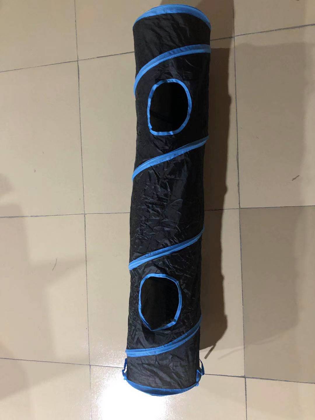 Black and blue pet tunnel on a tiled floor