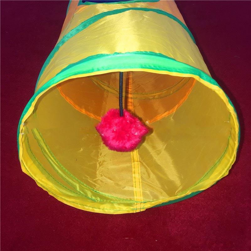 Yellow cat toy tunnel with a pink pom-pom on a red background