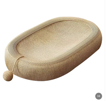An oval-shaped woven cat bed made of natural tan sisal rope, featuring a small ball toy attached by a string on one end, shown against a plain white background.