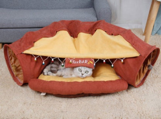 Red pet playpen with a yellow cushion, featuring two cats inside on a carpeted floor.