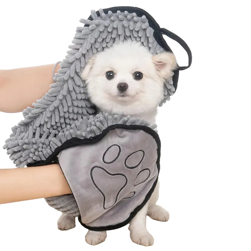 Small white dog wearing a gray chenille robe with a paw design on a light background