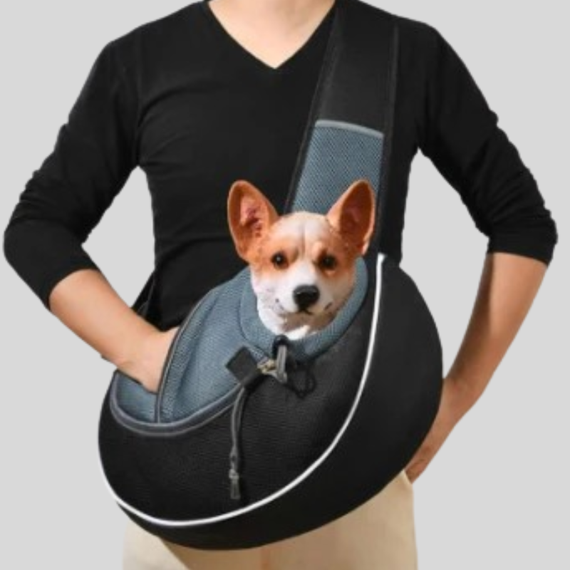 A dog carrier sling worn cross-body by a person, featuring a black mesh exterior, gray mesh panels, and a printed image of a small dog on the front, shown against a plain light gray background.