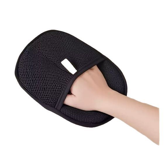 Black grooming mitt with gray pad, hand using it, and two pets on a white background
